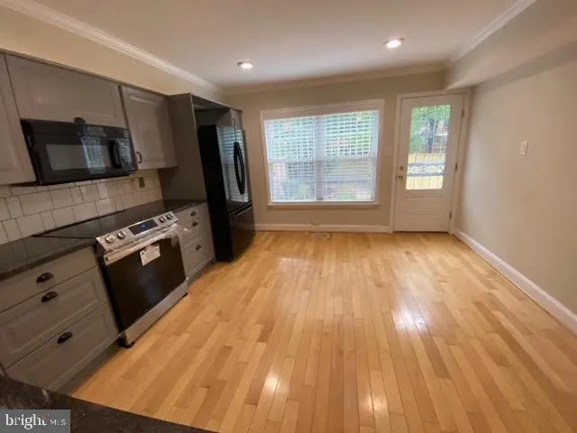 a view of kitchen with wooden floor electronic appliances and window