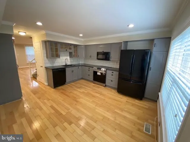 a large kitchen with a refrigerator a sink dishwasher and a stove