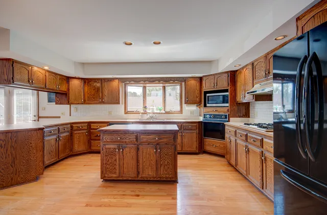 a kitchen that has a sink a stove and a wooden cabinets