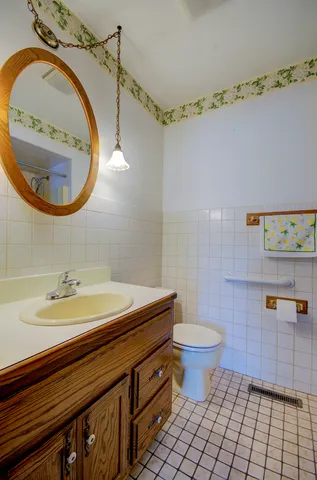 a bathroom with a sink a toilet and a mirror