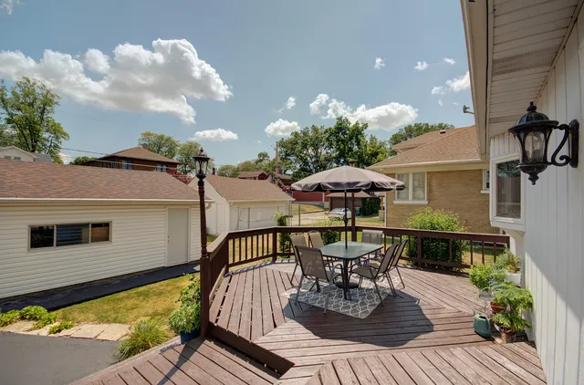 a view of a patio with a table chairs and wooden floor