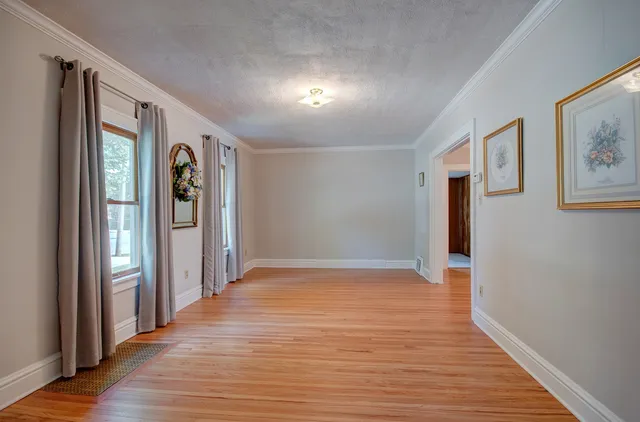 a view of an empty room with wooden floor