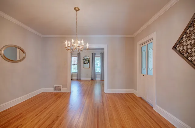 a view of a room with wooden floor and chandelier