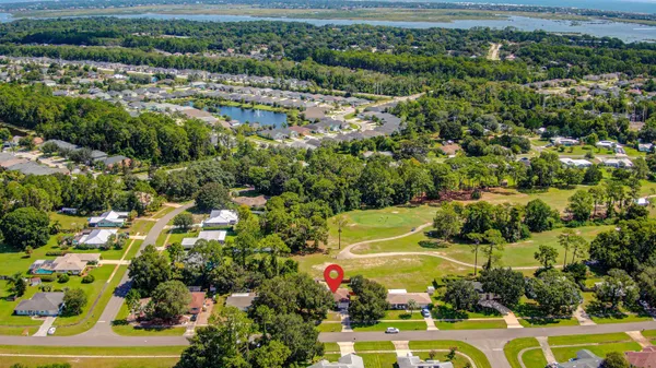 an aerial view of residential houses with outdoor space and trees