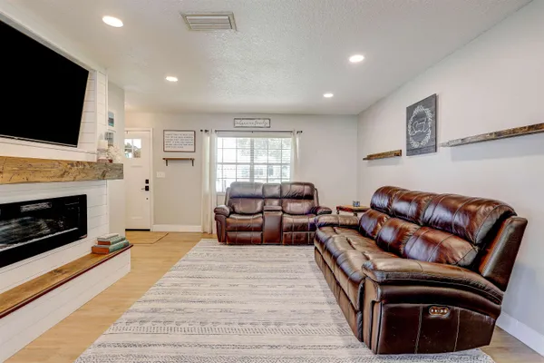 a living room with furniture a flat screen tv and a fireplace