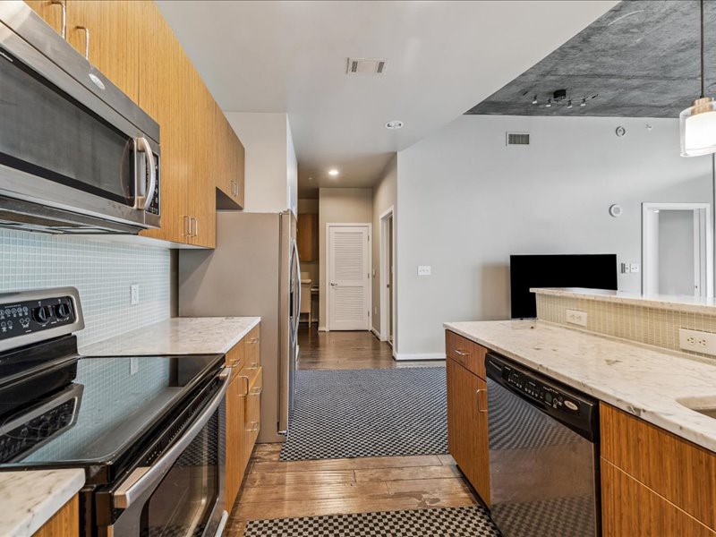 5925 Almeda Road, Unit 12704 Houston, TX 77004 - Photo 4 of 31 Modern elegance meets functionality in this chef-inspired kitchen. Clean lines, quality finishes, and an open connection to the living areas make this space both practical and visually appealing.