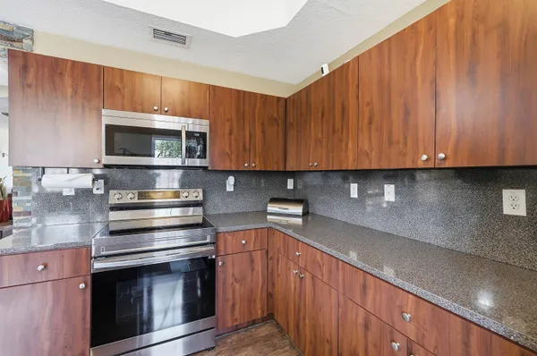 a kitchen with stainless steel appliances a stove a microwave sink and cabinets