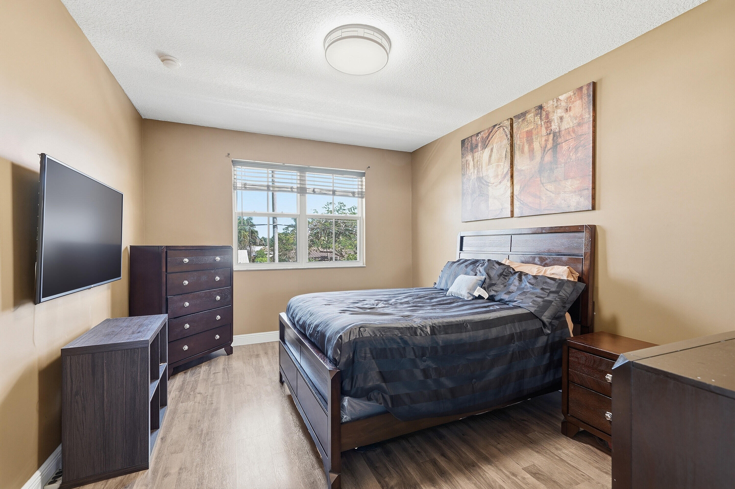 5825 Siena Lane Hollywood, FL 33021 - Photo 18 of 26 a bedroom with a bed and a flat tv screen on dresser