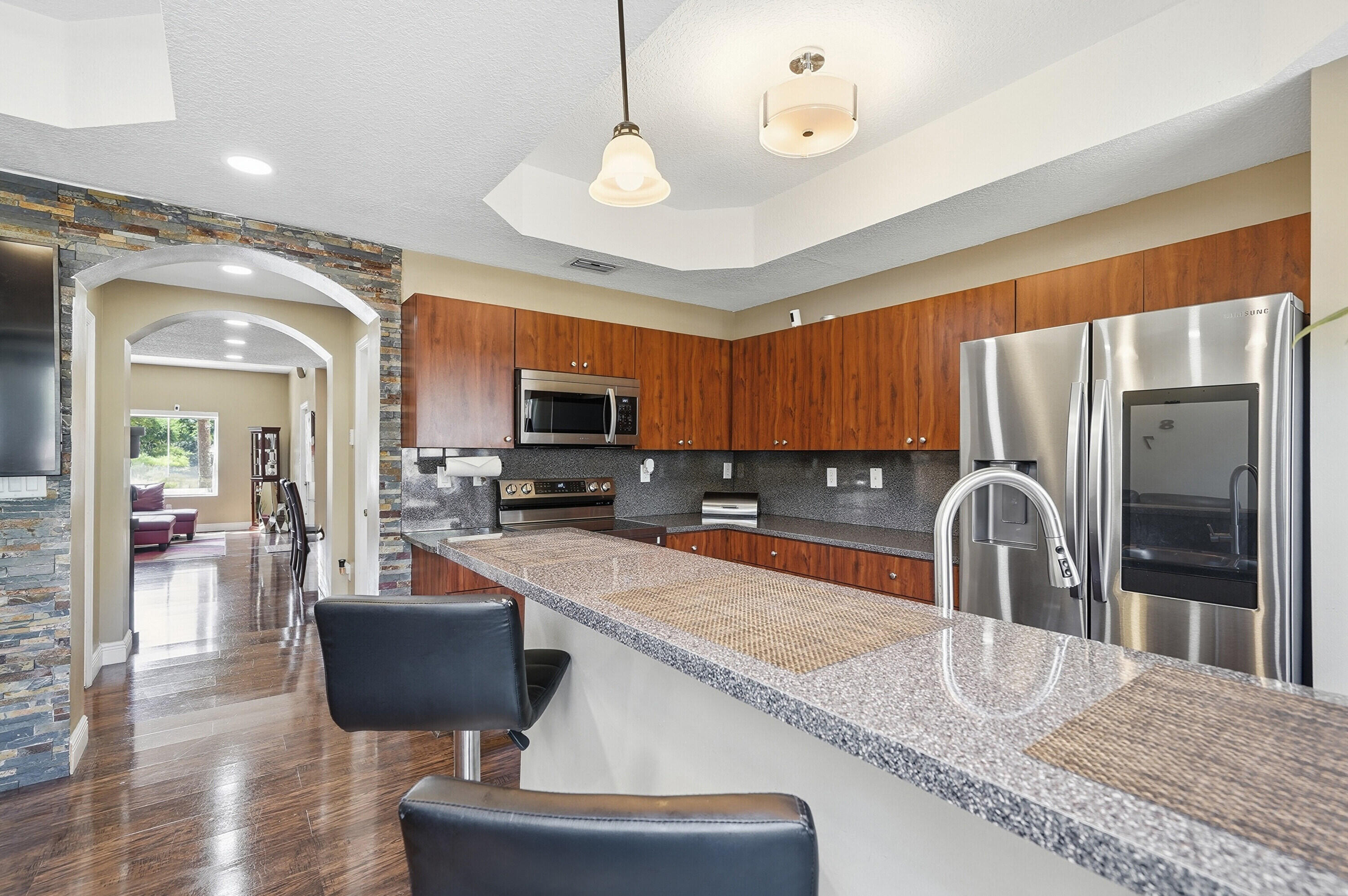 5825 Siena Lane Hollywood, FL 33021 - Photo 5 of 26 a kitchen with stainless steel appliances granite countertop a sink refrigerator stove and microwave