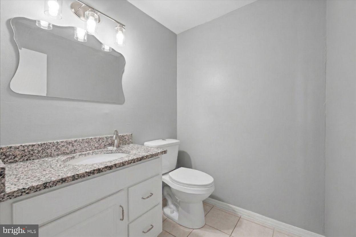 8513 Pamunkey Road Spotsylvania, VA 22551 - Photo 6 of 15 a bathroom with a granite countertop toilet sink mirror and vanity