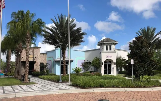 a view of a house with a yard and palm trees