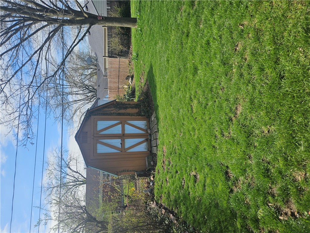6510 Longford Road Dayton, OH 45424 - Photo 9 of 27 This outdoor shed offers practical storage amidst a lush green lawn.