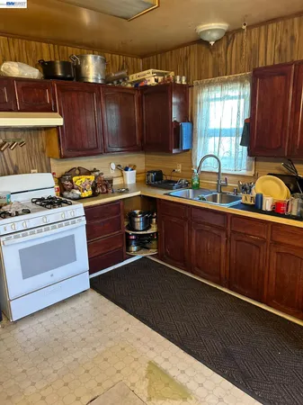 a kitchen with sink a stove and cabinets