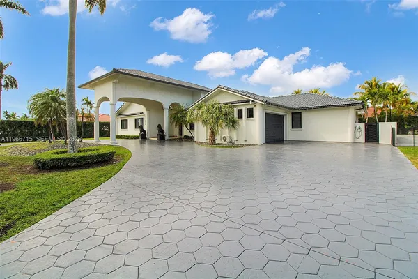 a front view of a house with a yard and potted plants