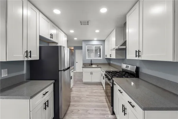 a kitchen with a refrigerator and a sink