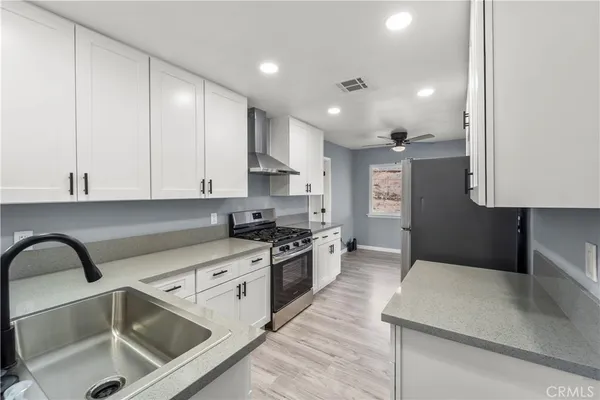 a kitchen with stainless steel appliances granite countertop a sink a stove and a refrigerator