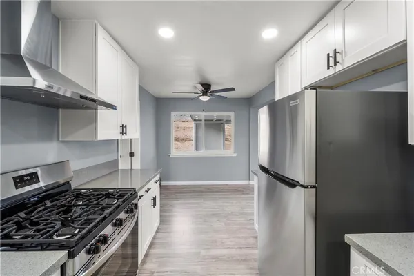 a kitchen with stainless steel appliances granite countertop a refrigerator and a stove