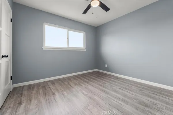 an empty room with a window and a ceiling fan