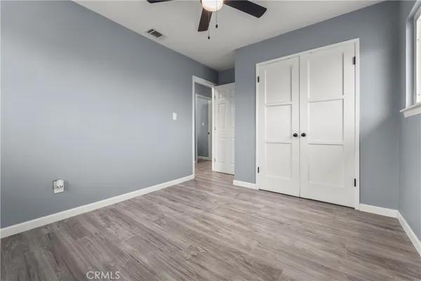 a view of an empty room with a window and a ceiling fan