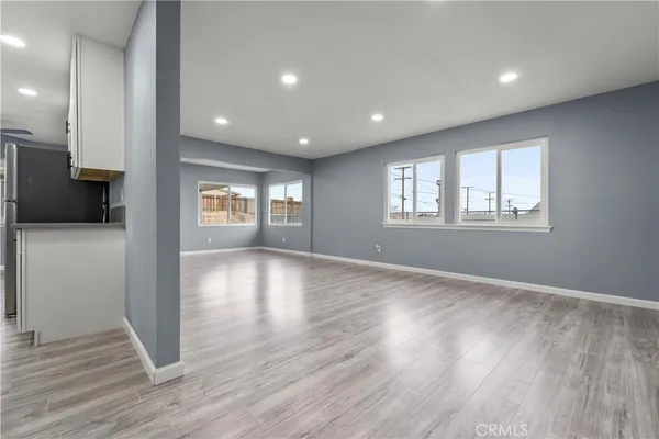 a view of empty room with window and wooden floor