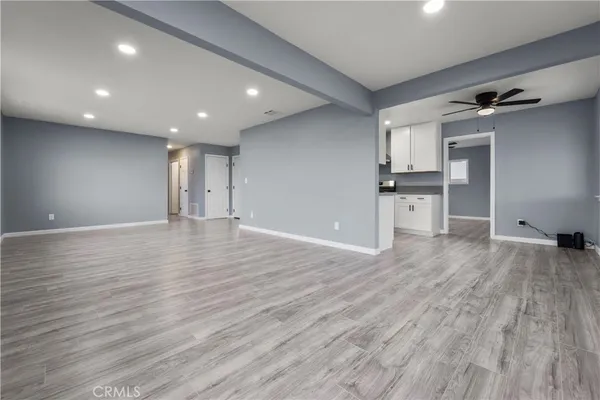 a view of empty room with wooden floor and windows