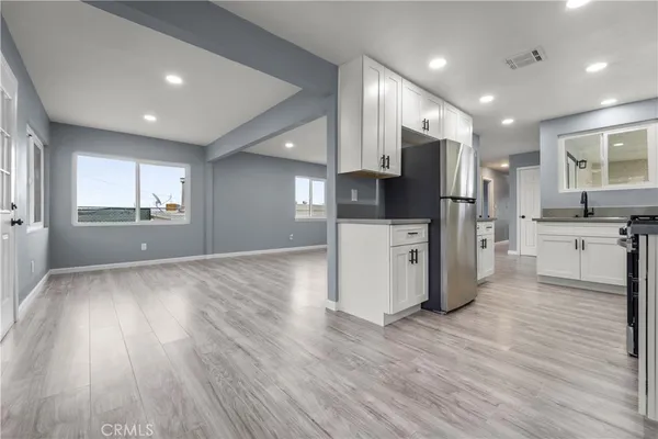 a kitchen with stainless steel appliances a refrigerator and wooden floor