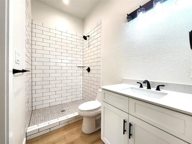 a bathroom with a sink a toilet and shower