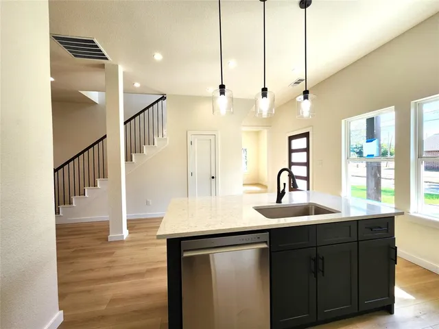 a kitchen with sink cabinets and wooden floor