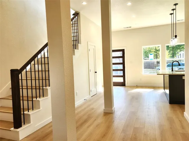 a view of a hallway with wooden floor and staircase