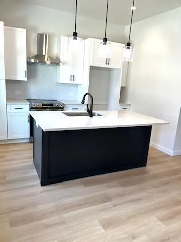 a kitchen with kitchen island stainless steel appliances a sink counter space and wooden floor