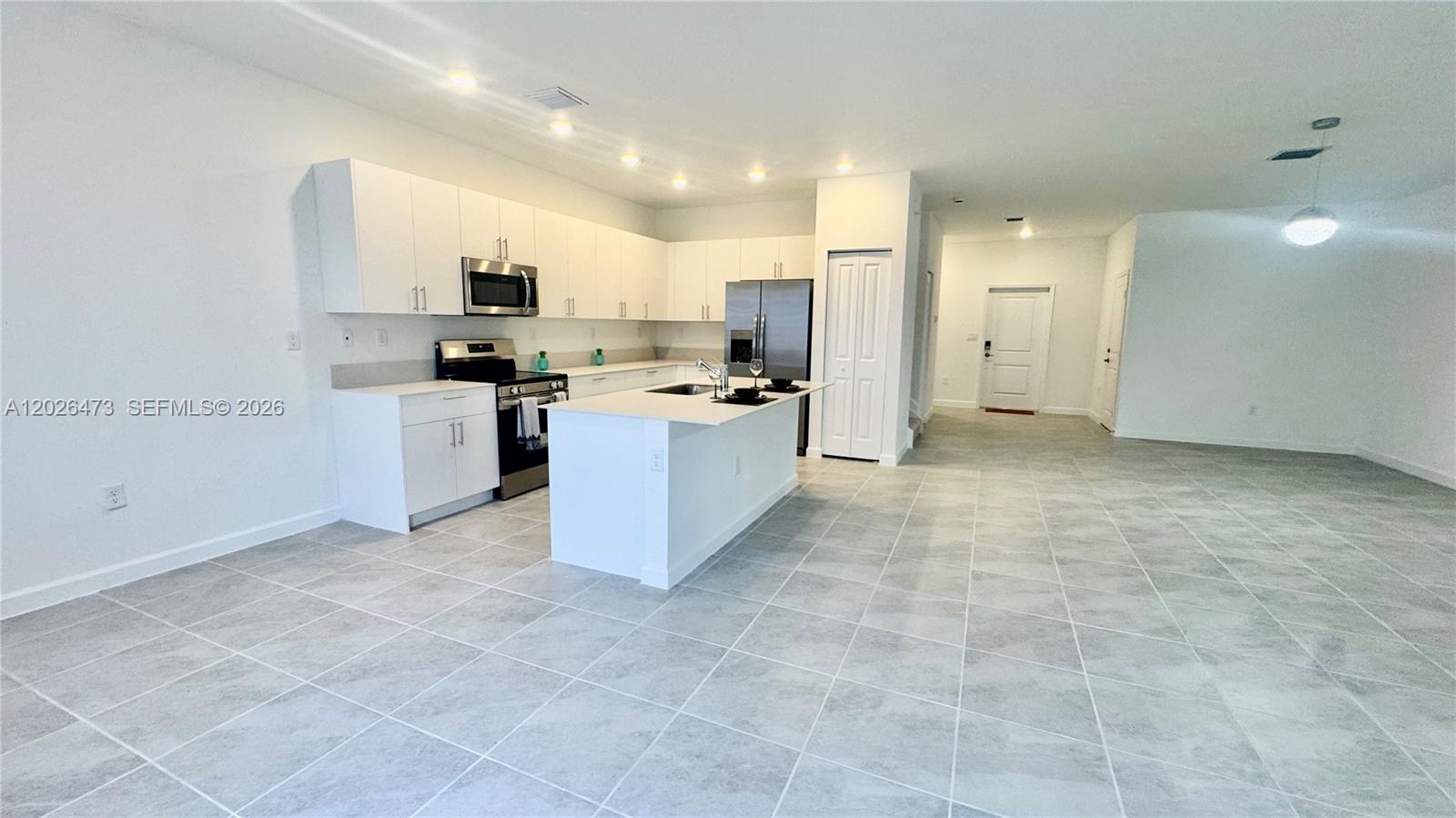 19479 Southwest 340th Street, Unit 1 Homestead, FL 33034 - Photo 34 of 58 a kitchen with stainless steel appliances a sink a stove a refrigerator and cabinets