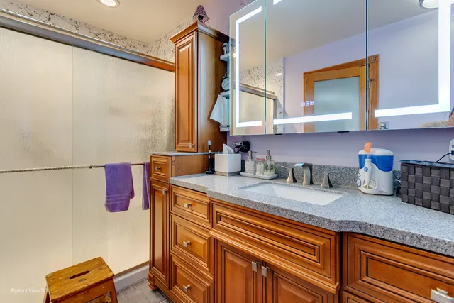 a bathroom with a granite countertop sink and a mirror