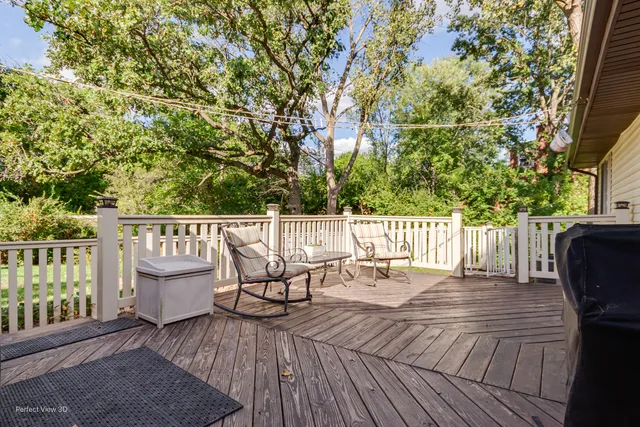 a view of deck with furniture and trees around