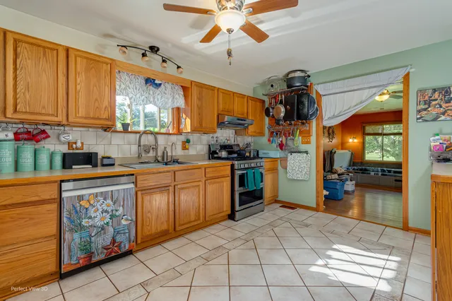 a kitchen with stainless steel appliances granite countertop a sink cabinets and window