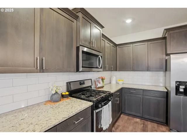 a kitchen with stainless steel appliances granite countertop a sink stove and refrigerator