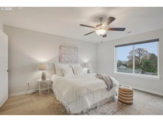 a bedroom with a bed and a painting on the wall