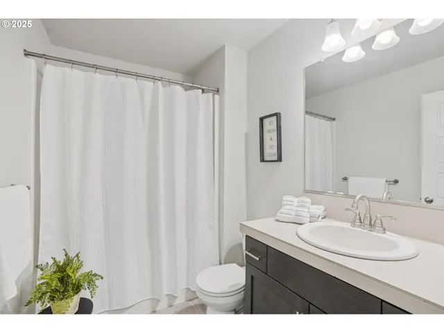 a bathroom with a sink vanity mirror and toilet