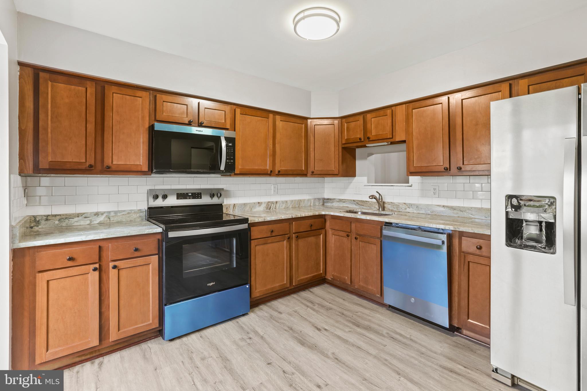 8617 Castlemill Circle Nottingham, MD 21236 - Photo 4 of 25 a kitchen with stainless steel appliances granite countertop a stove a sink dishwasher a refrigerator and a microwave oven