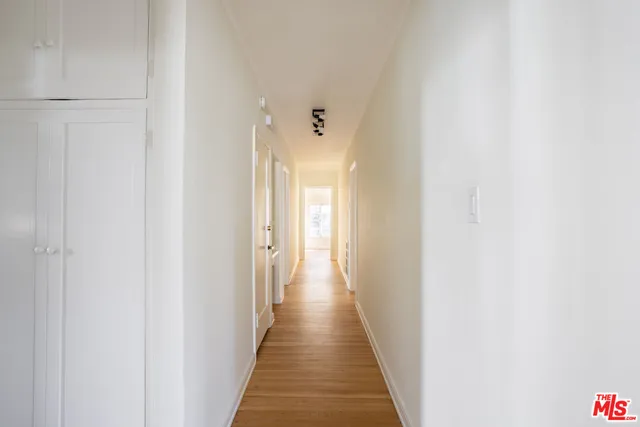 a view of a hallway with wooden floor