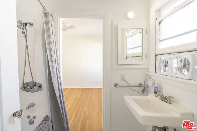 a bathroom with a tub sink and mirror