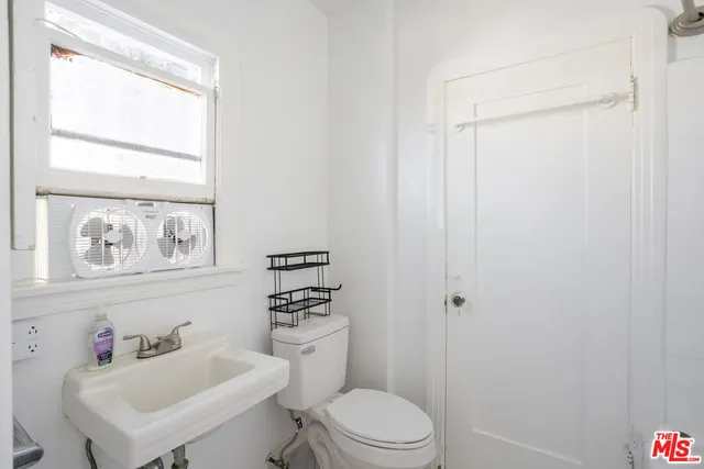 a bathroom with a toilet sink vanity and mirror