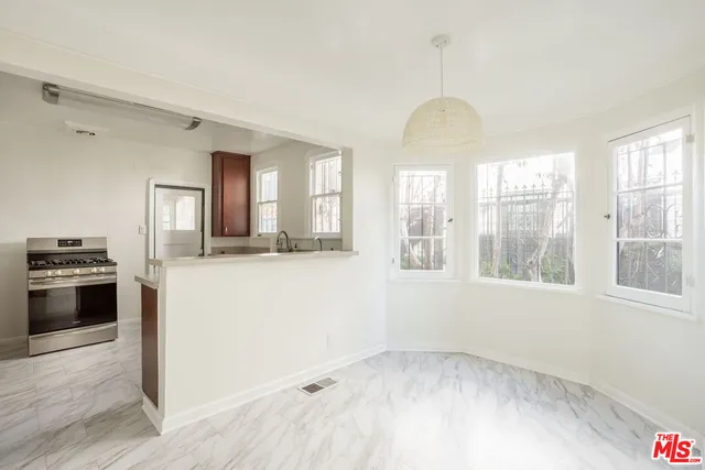 a view of a kitchen and an entryway with wooden floor