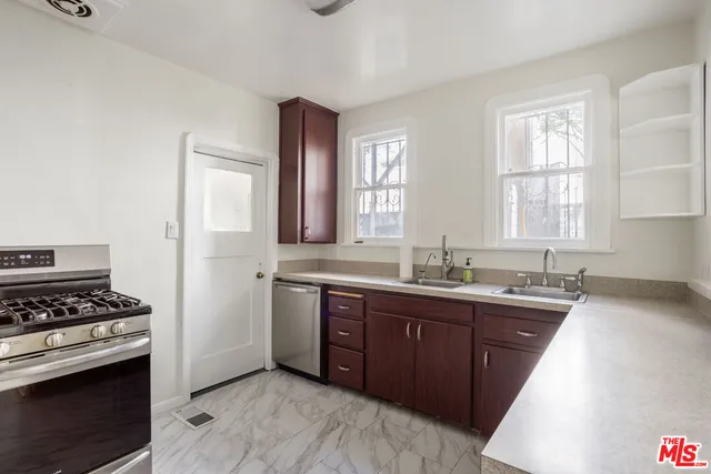 a kitchen with stainless steel appliances a sink stove and window
