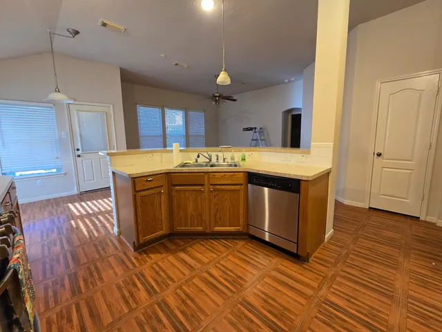 a kitchen with a sink and wooden floor