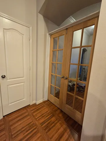 a view of an empty room with wooden floor and a window