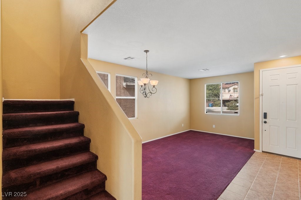5033 Ropers Rock Court Las Vegas, NV 89131 - Photo 9 of 40 Entryway featuring carpet floors, tile patterned floors, and a chandelier