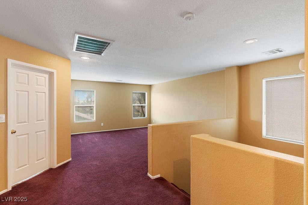 5033 Ropers Rock Court Las Vegas, NV 89131 - Photo 15 of 40 Hall featuring an upstairs landing, carpet flooring, and a textured ceiling