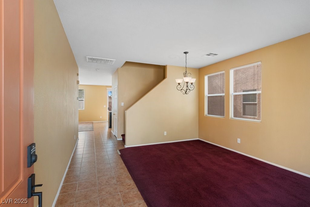 5033 Ropers Rock Court Las Vegas, NV 89131 - Photo 6 of 40 Empty room with a chandelier and tile patterned floors
