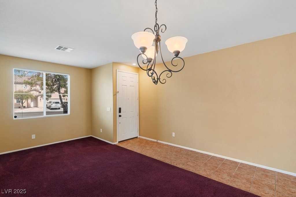 5033 Ropers Rock Court Las Vegas, NV 89131 - Photo 7 of 40 Unfurnished room with a chandelier, carpet floors, and tile patterned flooring