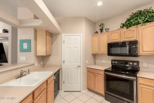 a kitchen with stainless steel appliances granite countertop a sink stove microwave and refrigerator
